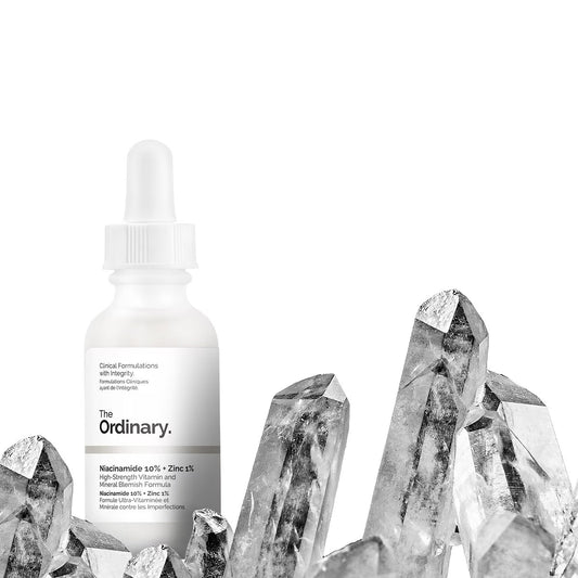 Skincare dropper bottle with crystals on a white background