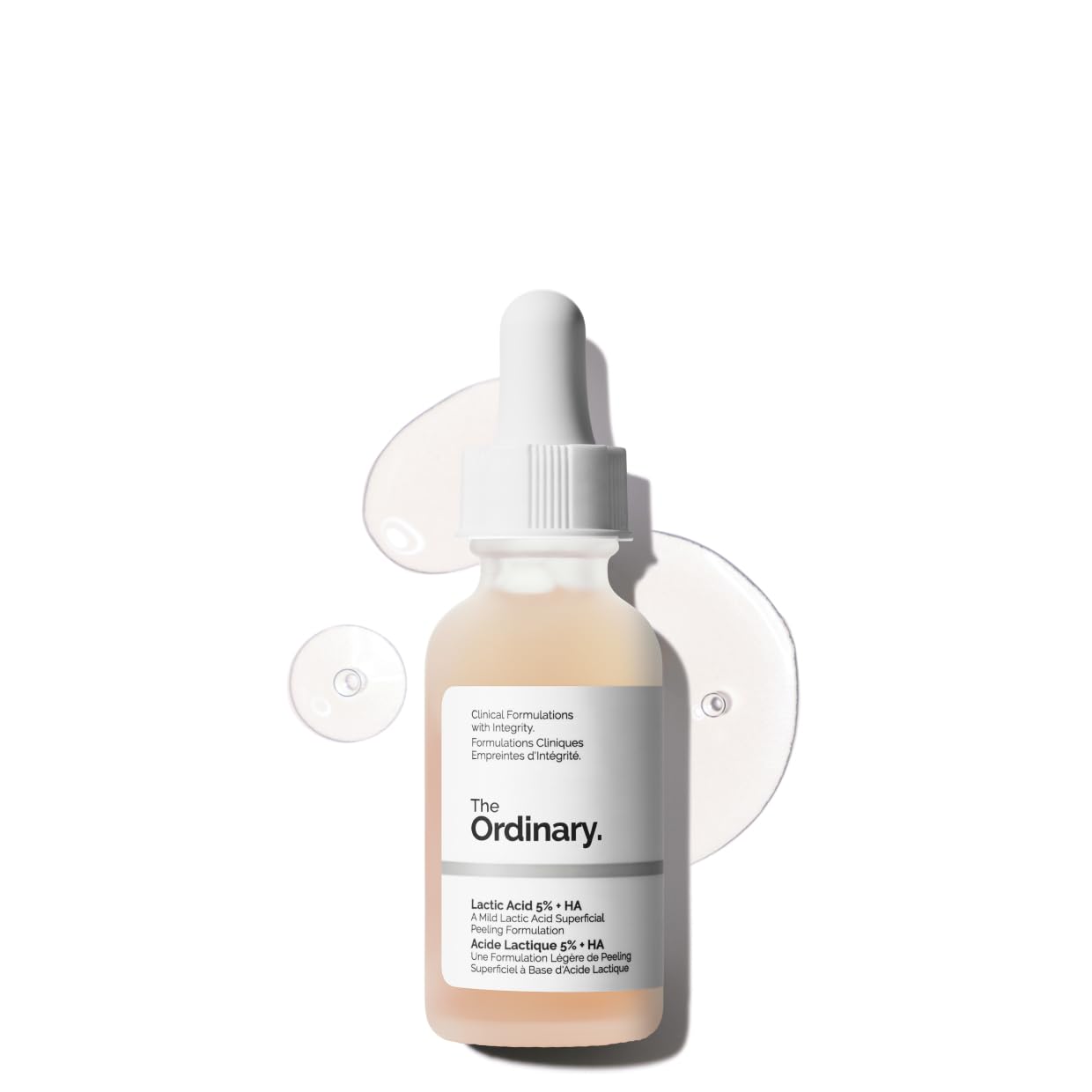 Product image of The Ordinary Lactic Acid 5% + HA exfoliating serum in a frosted glass dropper bottle. The serum is displayed against a clean white background with translucent serum drops, highlighting its lightweight texture. Formulated with lactic acid and hyaluronic acid to gently exfoliate, smooth skin texture, and support hydration.