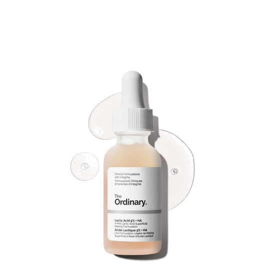Product image of The Ordinary Lactic Acid 5% + HA exfoliating serum in a frosted glass dropper bottle. The serum is displayed against a clean white background with translucent serum drops, highlighting its lightweight texture. Formulated with lactic acid and hyaluronic acid to gently exfoliate, smooth skin texture, and support hydration.