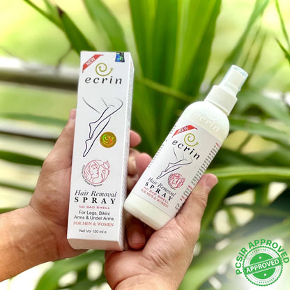 Ecrin hair removal spray bottle and packaging held in a hand with green leaves in the background