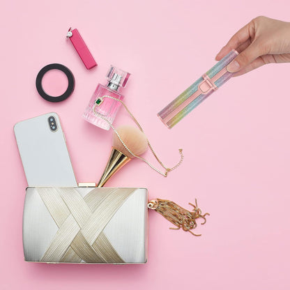 Collection of beauty products including a phone, perfume, brush, and clutch on a pink background