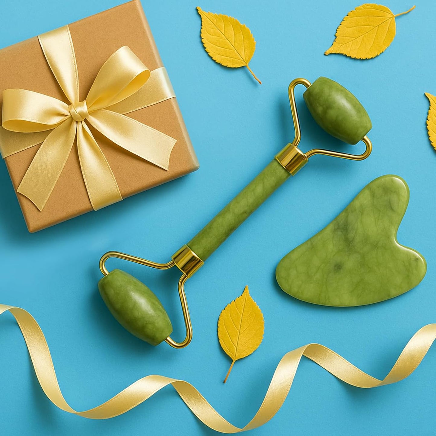Green facial roller and gua sha tool with a brown gift box on a blue background