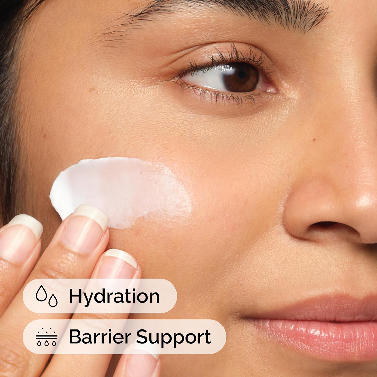 Close-up of a woman applying The Ordinary Natural Moisturizing Factors + Hyaluronic Acid moisturizer to her cheek. The image highlights key benefits including deep hydration and skin barrier support. Lightweight moisturizing cream helps strengthen the skin's natural barrier, lock in moisture, and keep skin soft, smooth, and healthy-looking throughout the day.