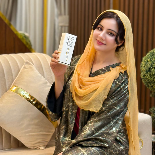 Woman in traditional attire holding a product box in an indoor setting