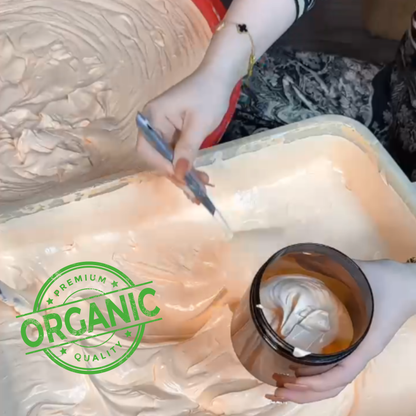 Person scooping organic cream into a container with a green 'Premium Organic Quality' label.