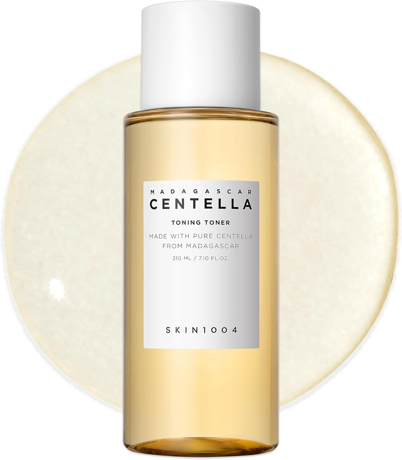 Front view of SKIN1004 Madagascar Centella Toning Toner 210ml bottle displayed against a toner texture backdrop. This hydrating Korean toner is enriched with Madagascar Centella Asiatica Extract, Hyaluronic Acid, and PHA to gently exfoliate, soothe irritation, improve skin texture, and maintain long-lasting moisture. Suitable for sensitive, dry, oily, and combination skin types.