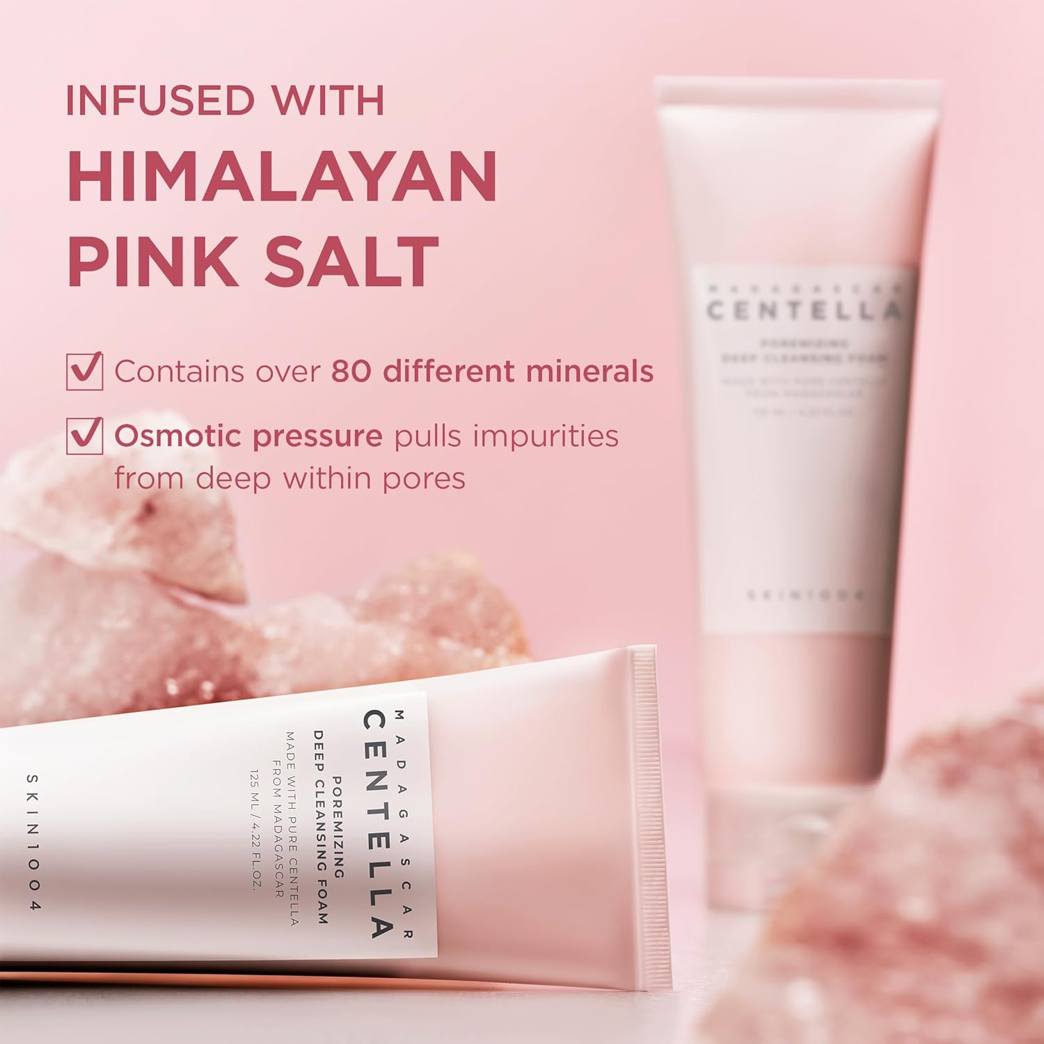 Promotional image of SKIN1004 Madagascar Centella Poremizing Deep Cleansing Foam highlighting Himalayan Pink Salt as a key ingredient. The image features two pink cleanser tubes surrounded by pink salt crystals and notes that the formula contains over 80 different minerals. It emphasizes osmotic pressure technology that helps draw impurities from deep within pores for a thorough cleanse, leaving skin refreshed and purified.