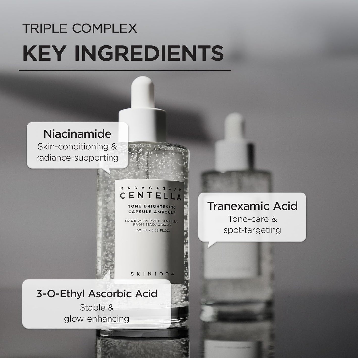 Informational image showcasing the key ingredients in SKIN1004 Madagascar Centella Tone Brightening Capsule Ampoule 100ml. Highlights Niacinamide for skin conditioning and radiance support, Tranexamic Acid for tone care and spot-targeting, and 3-O-Ethyl Ascorbic Acid for stable brightening and glow enhancement. Features the ampoule bottle with visible brightening capsules on a minimalist gray background.