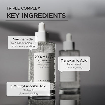 Informational image showcasing the key ingredients in SKIN1004 Madagascar Centella Tone Brightening Capsule Ampoule 100ml. Highlights Niacinamide for skin conditioning and radiance support, Tranexamic Acid for tone care and spot-targeting, and 3-O-Ethyl Ascorbic Acid for stable brightening and glow enhancement. Features the ampoule bottle with visible brightening capsules on a minimalist gray background.