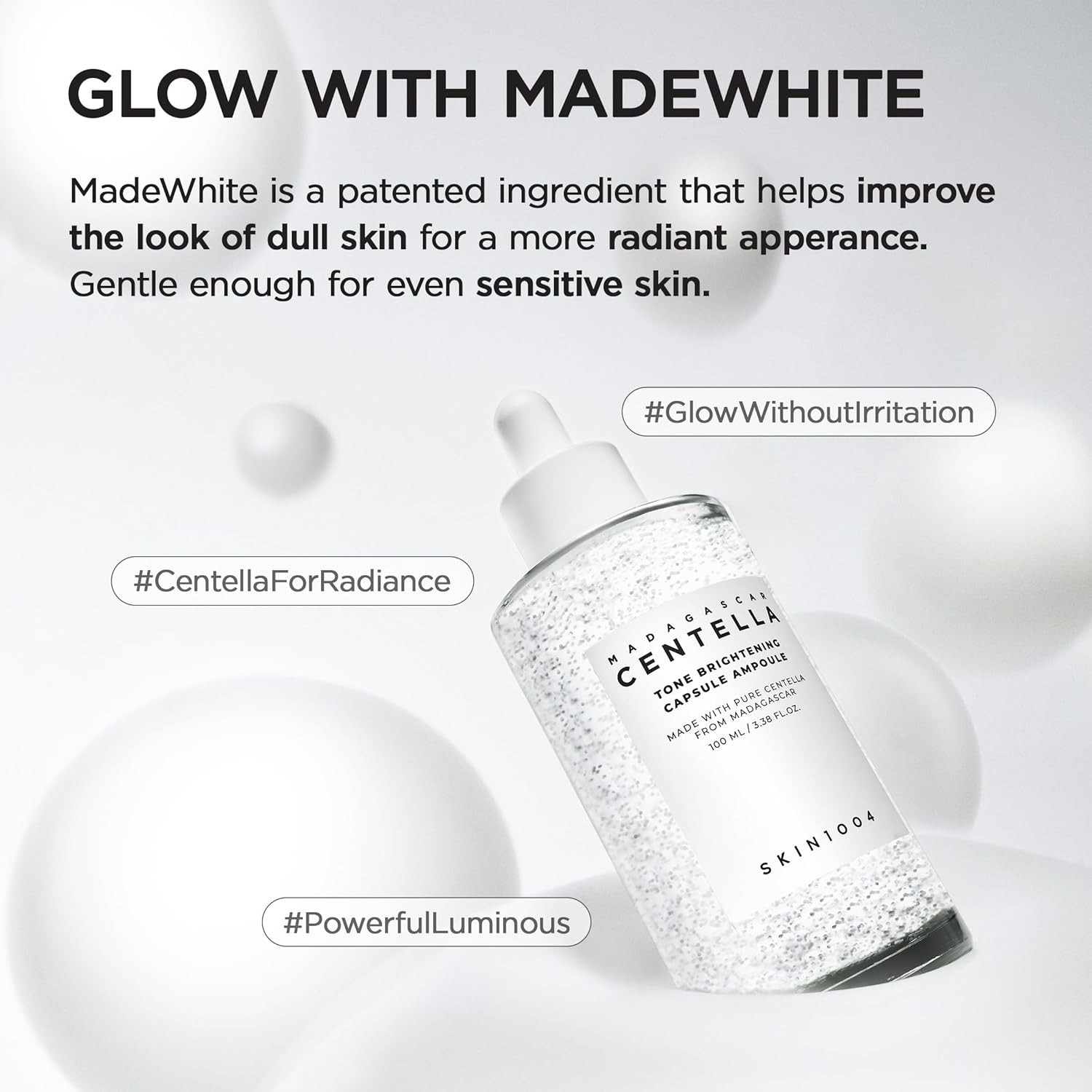 Promotional image of SKIN1004 Madagascar Centella Tone Brightening Capsule Ampoule 100ml featuring MadeWhite™ technology for radiant-looking skin. Highlights brightening benefits, glow enhancement, and suitability for sensitive skin. The serum bottle with brightening capsules is displayed on a clean white background with floating spheres and messaging about luminous, irritation-free skincare.