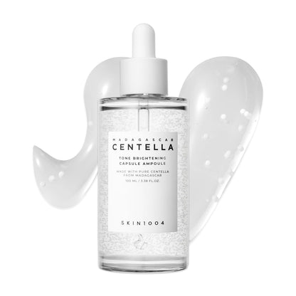 SKIN1004 Madagascar Centella Tone Brightening Capsule Ampoule 100ml serum bottle with dropper applicator. Features brightening capsule technology suspended in a lightweight hydrating formula designed to improve uneven skin tone, enhance radiance, and provide soothing care with Centella Asiatica. Displayed against a clean white background with serum texture swatches.