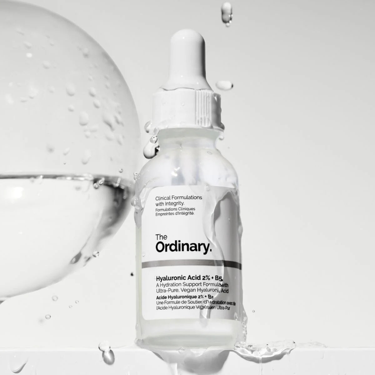 Skincare serum bottle labeled 'The Ordinary' with dropper on a light gray background