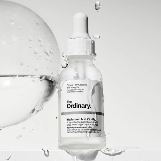 Skincare serum bottle labeled 'The Ordinary' with dropper on a light gray background
